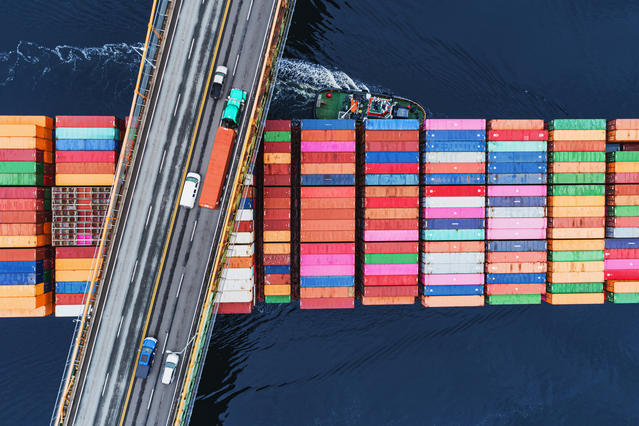 Overview photo of a container ship beneath a bridge